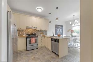 eine Küche mit Herd und Kühlschrank in der Unterkunft Tranquil Haven near Niagara in Thorold