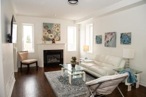 ein Wohnzimmer mit einer weißen Couch und einem Kamin in der Unterkunft Tranquil Haven near Niagara in Thorold