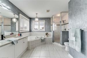 ein Badezimmer mit Badewanne und Dusche und Toilette in der Unterkunft Tranquil Haven near Niagara in Thorold + 39 Fotos