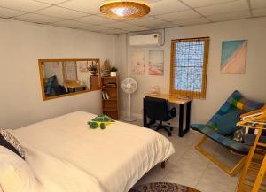 a bedroom with a bed and a desk and a chair at Bamboo Beach House @ Phang Nga in Thai Muang