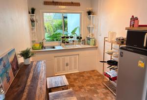 eine Küche mit Tisch und Spüle und Fenster in der Unterkunft Bamboo Beach House @ Phang Nga in Thai Muang