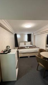 a bedroom with a bed and a table and chairs at New Hotel Harbiye in Istanbul