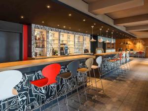 a bar with red and white stools in a restaurant at ibis Hotel München Garching in Garching bei München