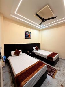 a bedroom with two beds and a ceiling at Hotel Pratyaksh Darshan in Varanasi