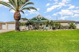 a palm tree in front of a house at 445 Watts Way in Cocoa Beach