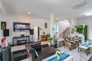 ein Wohnzimmer mit Sofa und Fernseher in der Unterkunft Lebest Pool Villa Chiang Mai in Ban Mai