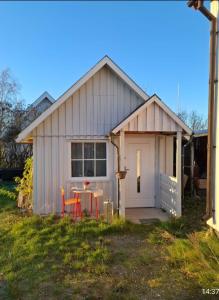 a white shed with a table in front of it at trygga huset in Sigtuna