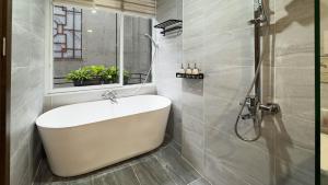 a bathroom with a white tub and a shower at Home Homestay in Hanoi +176 photos