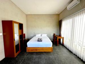Una cama o camas en una habitación de Mutiara Homestay Uluwatu