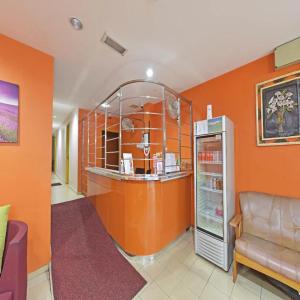 a room with an orange wall with a refrigerator at Haven Hotel Cheras in Kuala Lumpur
