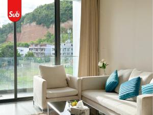 a living room with a couch and a large window at Modern Haven Suite in Hat Yai in Ban Thung Ngai