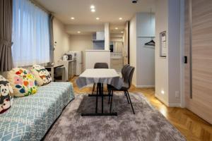 a living room with a couch and a table at ローズパーク十番館 in Narashino