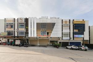 a large building with a white facade with cars parked in front at Urbanview near Mall Botania 2 in Pulau Sembakau Besar