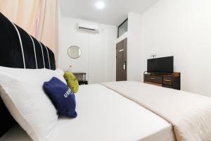 a bedroom with a large white bed with blue pillows at Urbanview near Mall Botania 2 in Pulau Sembakau Besar