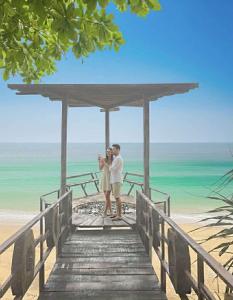 Ein Mann und eine Frau stehen auf einem Steg am Strand in der Unterkunft Dansontayakohlibong in Ko Libong Island + 55 Fotos
