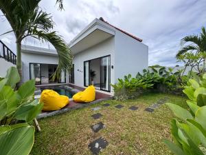 a house with yellow bean bags in the yard at Aloka Villa -Stylish 2 bedroom villa in the heart of Seseh in Munggu