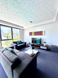 a living room with a couch and a tv at Ipanema Holiday Resort in Gold Coast