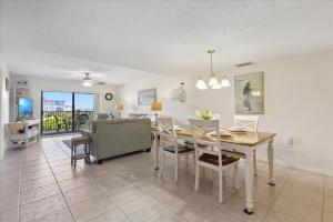 een eetkamer en woonkamer met een tafel en stoelen bij Windrush 509 in Cocoa Beach