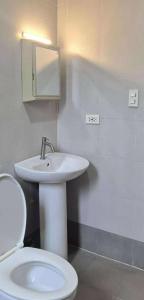 a bathroom with a white sink and a toilet at Beach Side Cabin San Juan ELYU in San Juan +25 photos