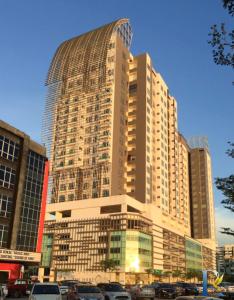 a large building with cars parked in front of it at Manhattan at Austin By RR JBcity in Gua Sai