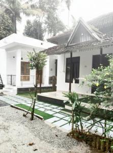 une maison blanche avec un jardin en face dans l'établissement Munroe Heritage Inn, à Munroe Island
