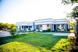 un grande edificio con un prato davanti di The Two Colonies Vacation Rental Homes a Lusaka