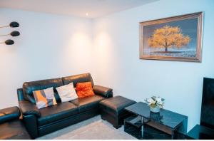 a living room with a leather couch and a table at Cozy room in yellow in Sale
