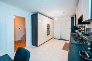 a kitchen with a stove top oven next to a hallway at Cozy room in yellow in Sale