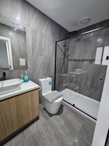 a bathroom with a shower and a toilet and a sink at Maruve Guesthouse Plus- Modern Stay near Melb Airport 12 min in Melbourne