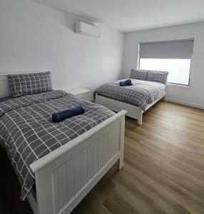 a bedroom with two beds and a window at Maruve Guesthouse Plus- Modern Stay near Melb Airport 12 min in Melbourne