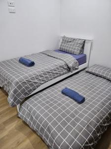 zwei Einzelbetten mit blauen Kissen in einem Zimmer in der Unterkunft Maruve Guesthouse Plus- Modern Stay near Melb Airport 12 min in Melbourne + 33 Fotos
