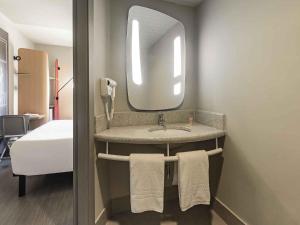 ein Badezimmer mit Waschbecken und Spiegel in der Unterkunft ibis Guaiba in Guaíba + 52 Fotos