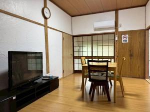 a room with a table and chairs and a clock at Seasid830 in Kuranomoto