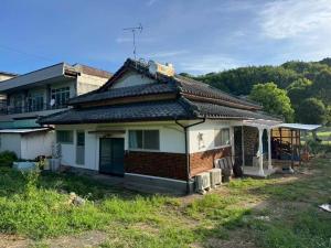 a house that is sitting in the grass at Seasid830 in Kuranomoto