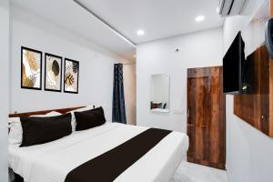 a bedroom with a black and white bed and a tv at Collection O Kachiguda Bus Terminal Hyderabad in Hyderabad