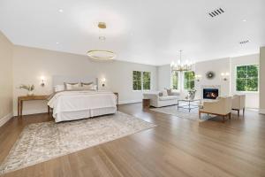 ein weißes Schlafzimmer mit einem Bett und einem Kamin in der Unterkunft The Polished Pearl Estate — Luxe Retreat/Pool/Spa in Saddle River + 85 Fotos