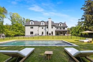 ein Grundstück mit einem Pool vor einem Haus in der Unterkunft The Polished Pearl Estate — Luxe Retreat/Pool/Spa in Saddle River