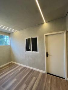 an empty room with a door and a window at Carneiro Hotel in Itatiba