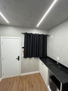 a room with a door and a black curtain at Carneiro Hotel in Itatiba