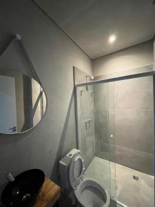 a bathroom with a toilet and a glass shower at Carneiro Hotel in Itatiba