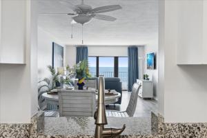un salon avec une table de salle à manger avec un ventilateur de plafond dans l'établissement Boardwalk 401, à Cocoa Beach