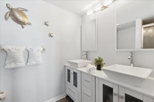 une salle de bain avec deux lavabos et une tortue sur le mur dans l'établissement Boardwalk 401, à Cocoa Beach 36 autres photos