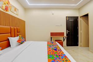 a bedroom with a bed with a colorful comforter at Hotel RA Apartment in Chennai