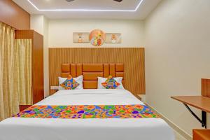 a bedroom with a large bed with a wooden headboard at Hotel RA Apartment in Chennai