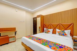 a bedroom with a large bed with a wooden headboard at Hotel RA Apartment in Chennai