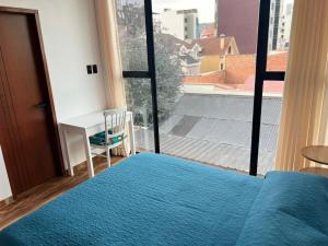 a bedroom with a blue bed and a large window at Excelente ubicación, cálido, siéntete en casa in La Paz