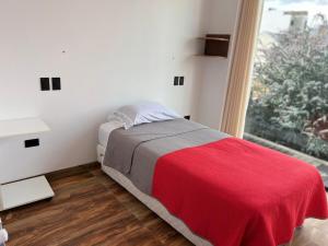 a bedroom with a bed with a red blanket and a window at Excelente ubicación, cálido, siéntete en casa in La Paz +19 photos