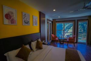 Una habitación de hotel con una cama, una mesa y sillas. en Hotel White Flower, en Jāmb