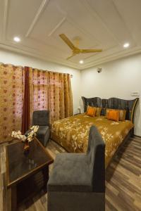 a bedroom with a bed and a ceiling fan at The Shesh Bagh Boutique - Garden Stay Near Dal Lake & Mughal Garden in Srinagar