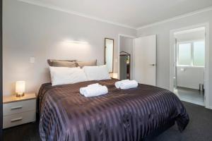 une chambre avec un grand lit avec deux serviettes dessus dans l'établissement Hamurana Hotspot - Walk to the Lake & Golf Course, à Hamurana 16 autres photos